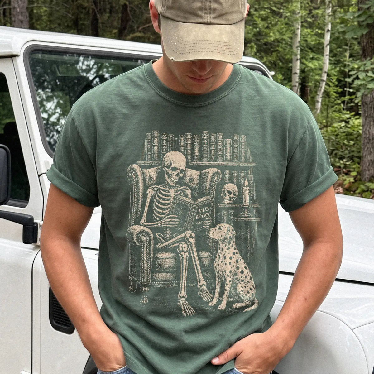 Model wearing a Moss Comfort Colors® T-shirt showing skeleton reading in a library beside a Dalmatian