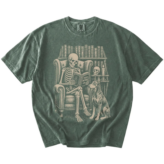 Skeleton reading in a library beside a Doberman on a Moss Comfort Colors® T-shirt