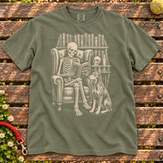 Skeleton reading in a library beside a Doberman on a Moss Comfort Colors® T-shirt