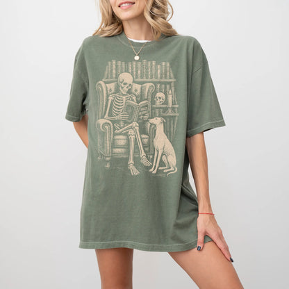 Model wearing a Moss Comfort Colors® T-shirt showing skeleton reading in a library beside a Greyhound