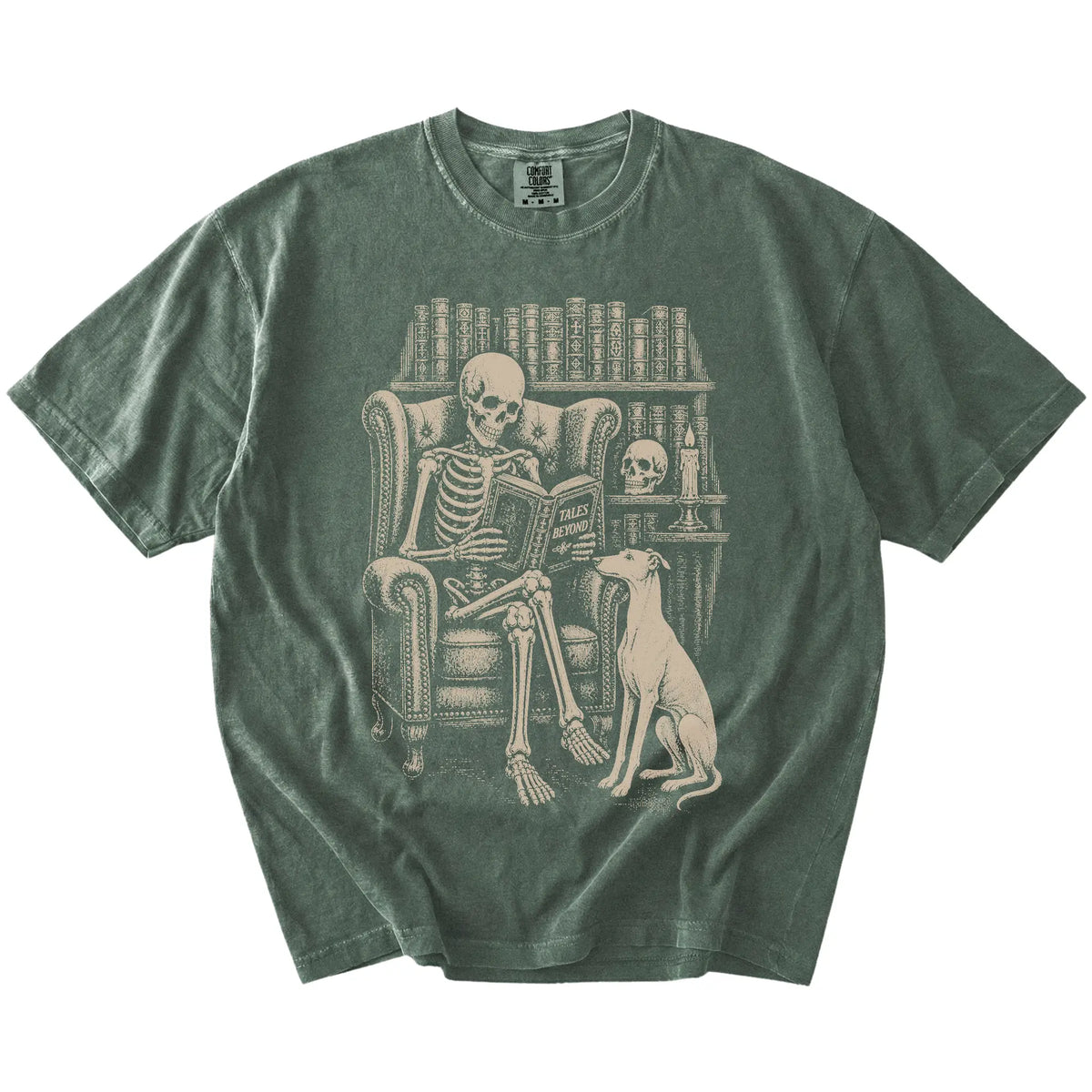Skeleton reading in a library beside a Greyhound on a Moss Comfort Colors® T-shirt