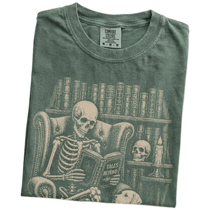 Folded Moss Comfort Colors® T-shirt showing skeleton reading in a library beside a Labrador Retriever