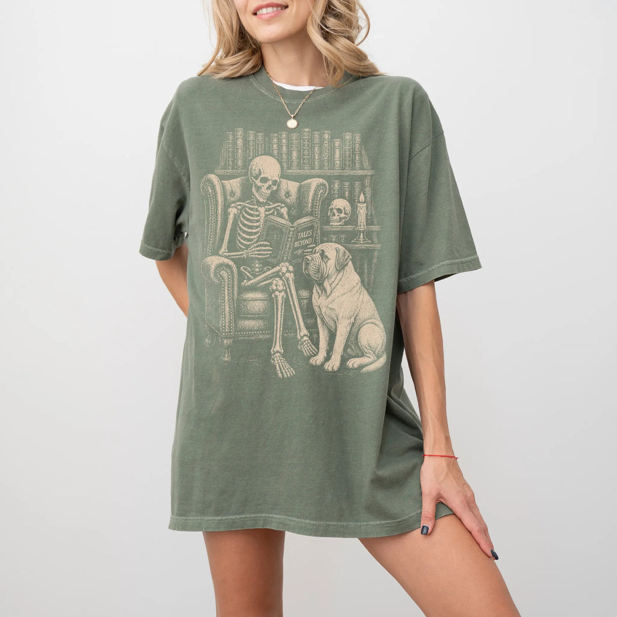 Model wearing a Moss Comfort Colors® T-shirt showing skeleton reading in a library beside a Mastiff