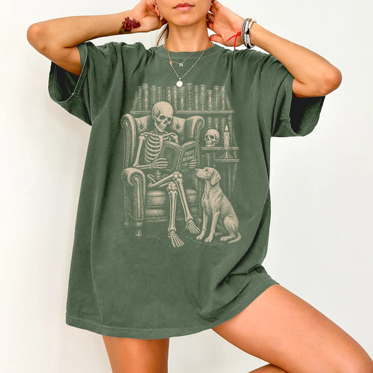 Model wearing a Moss Comfort Colors® T-shirt showing skeleton reading in a library beside a Weimaraner