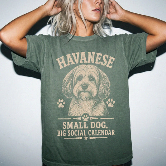 Model wearing a Moss Comfort Colors® T-shirt featuring Havanese design with “Small Dog, Big Social Calendar” lettering