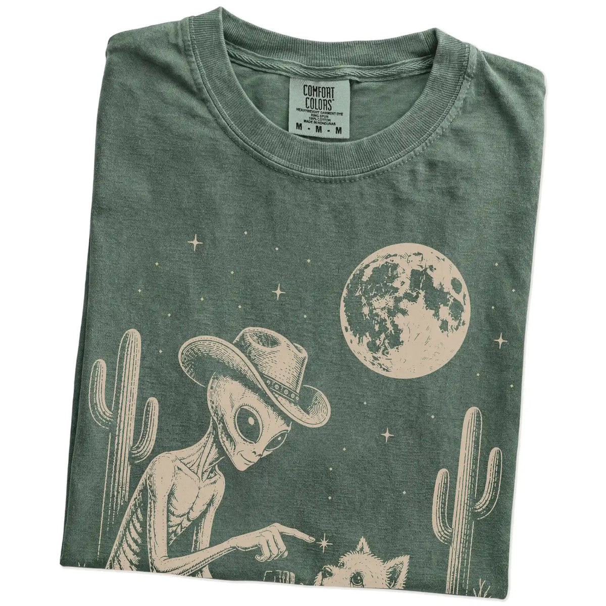 Folded Moss Comfort Colors® T-shirt showing cowboy alien fist-bumping a westie beneath the moon