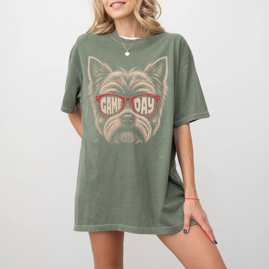 Model wearing a Moss Comfort Colors® T-shirt with yorkie wearing red game day sunglasses
