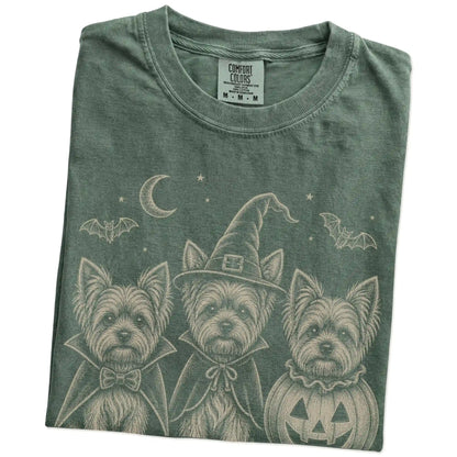 Folded Moss Comfort Colors® T-shirt showing three Yorkie dogs dressed for Halloween beneath bats and a crescent moon