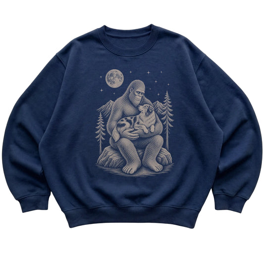 Navy crewneck sweatshirt with Bigfoot holding an Australian Shepherd under a moonlit sky