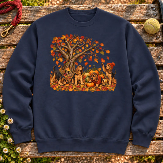 Four Bloodhound puppies with pumpkins beneath an autumn tree on a Navy crewneck sweatshirt