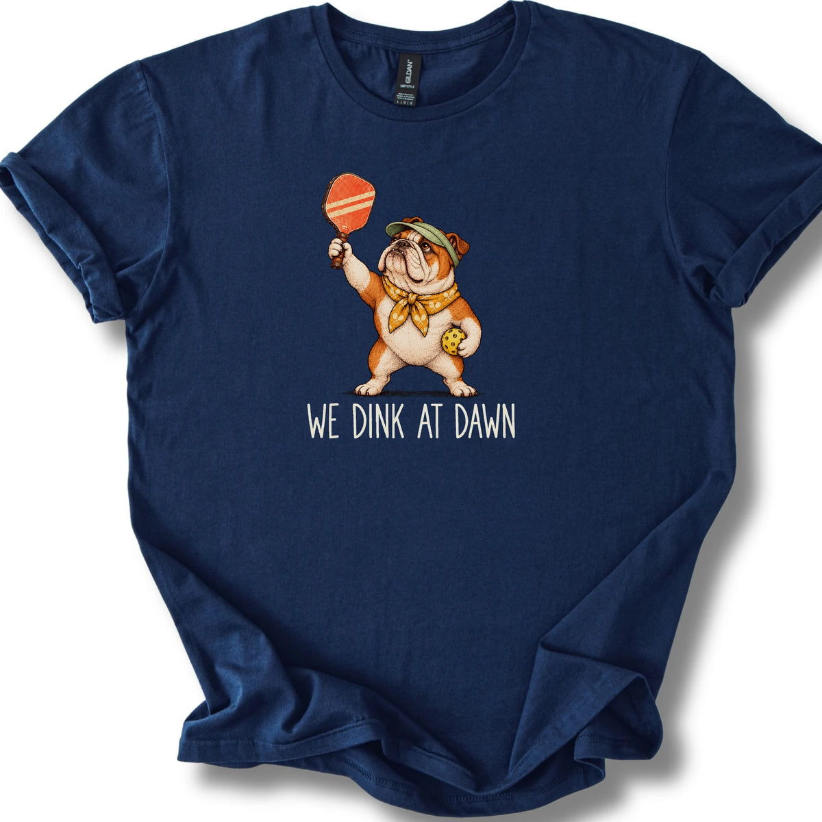 Bulldog with a pickleball paddle and ball on a Navy Gildan® T-shirt with We Dink at Dawn text