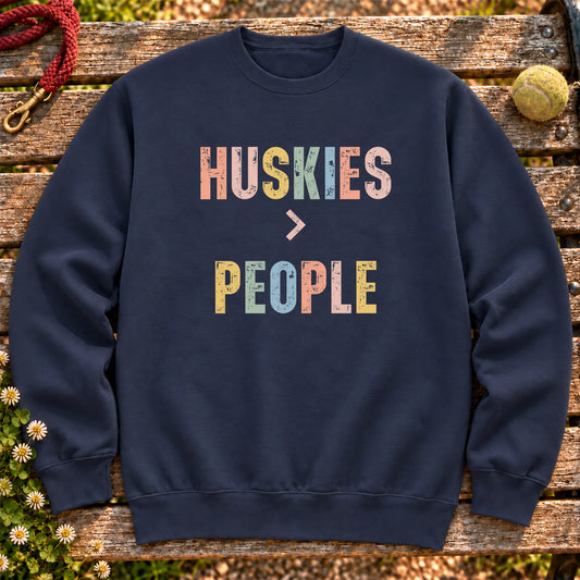 Huskies greater than people text design on a Navy crewneck sweatshirt