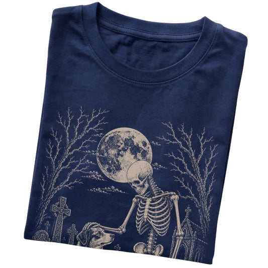 Folded Navy T-shirt with a skeleton petting an Australian Shepherd in a graveyard