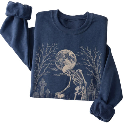 Folded Navy sweatshirt with a skeleton petting a Dalmatian in a graveyard