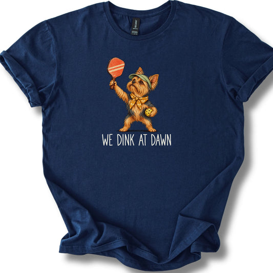 Yorkie with a pickleball paddle and ball on a Navy Gildan® T-shirt with We Dink at Dawn text