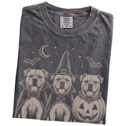 Folded Pepper Comfort Colors® T-shirt showing three American Bulldog dogs dressed for Halloween beneath bats and a crescent m