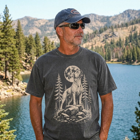 Model wearing a Pepper Comfort Colors® T-shirt with a American Bulldog howling beneath the moon and pine trees