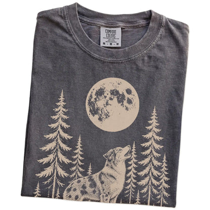Folded Pepper Comfort Colors® T-shirt showing a Australian Shepherd howling beneath the moon and pine trees