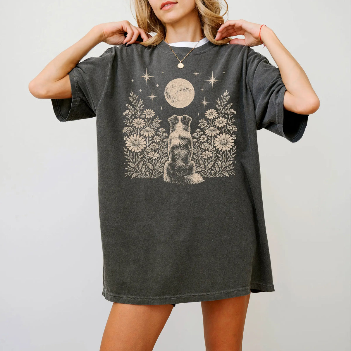 Model wearing a Pepper Comfort Colors® T-shirt featuring Australian Shepherd beneath a wildflower moon