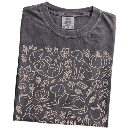 Folded Pepper Comfort Colors® T-shirt showing Beagle dogs with pumpkins, leaves, acorns, and woodland details