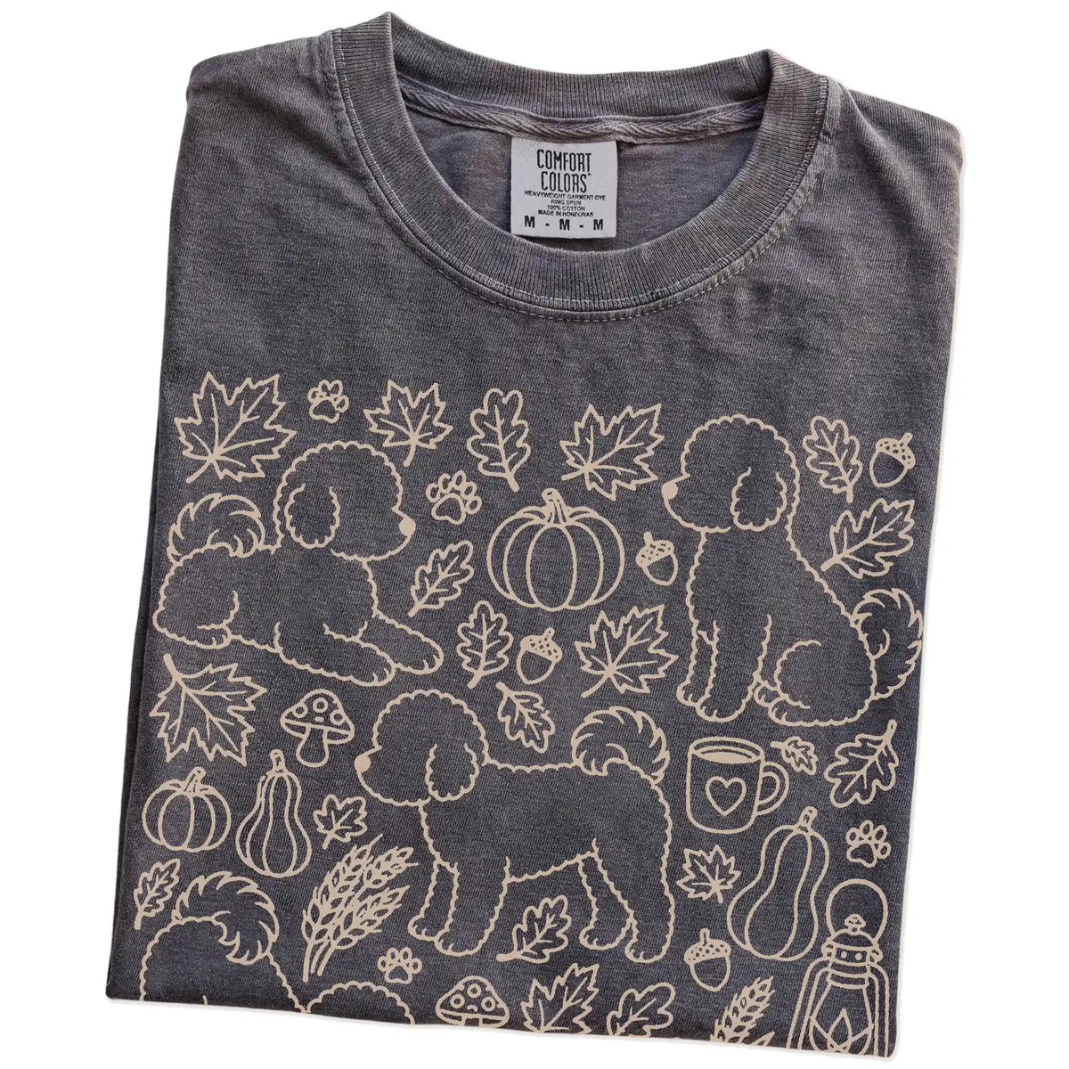 Folded Pepper Comfort Colors® T-shirt showing Bichon Frise dogs with pumpkins, leaves, acorns, and woodland details