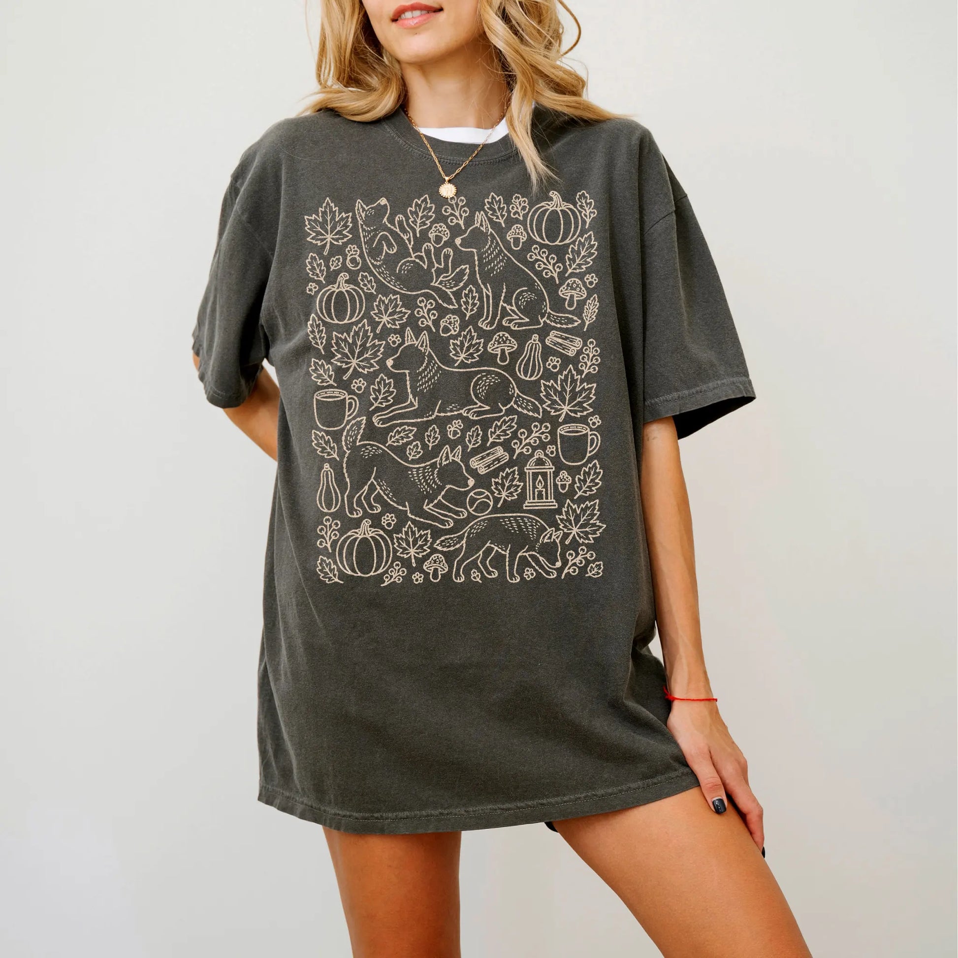 Model wearing a Pepper Comfort Colors® T-shirt with Blue Heeler dogs with pumpkins, leaves, acorns, and woodland details