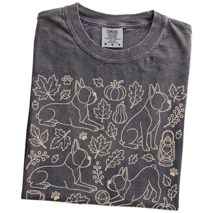 Folded Pepper Comfort Colors® T-shirt showing Boston Terrier dogs with pumpkins, leaves, acorns, and woodland details
