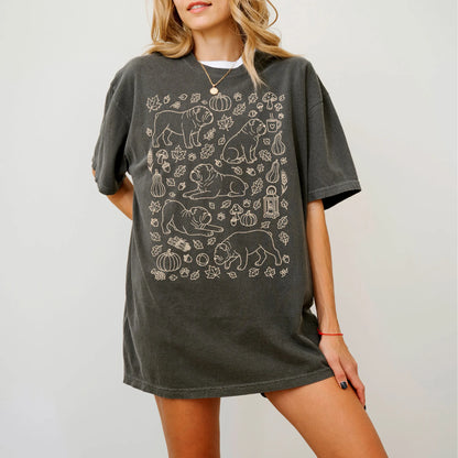Model wearing a Pepper Comfort Colors® T-shirt with Bulldog dogs with pumpkins, leaves, acorns, and woodland details