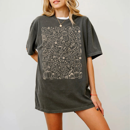 Model wearing a Pepper Comfort Colors® T-shirt with Dalmatian dogs with pumpkins, leaves, acorns, and woodland details