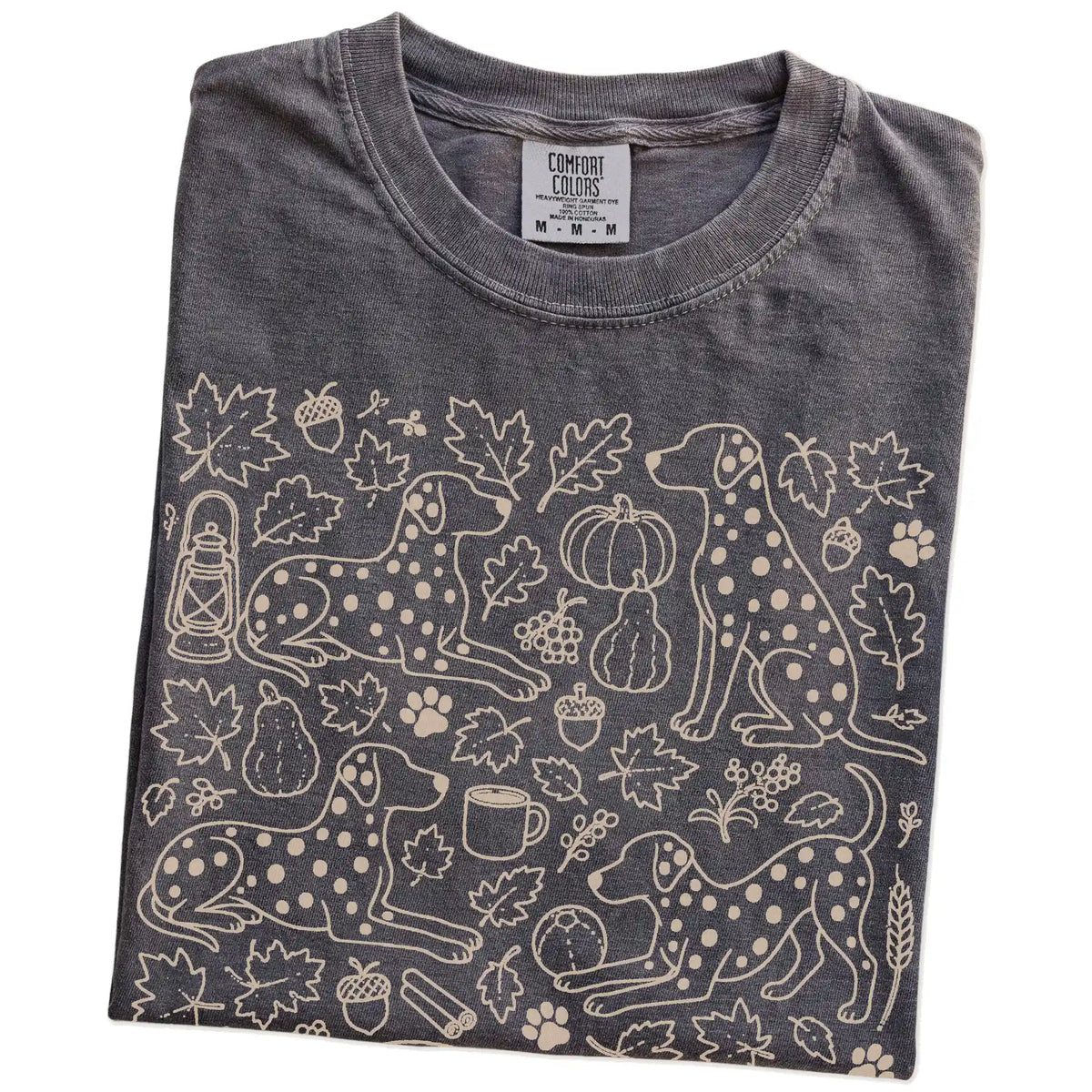 Folded Pepper Comfort Colors® T-shirt showing Dalmatian dogs with pumpkins, leaves, acorns, and woodland details
