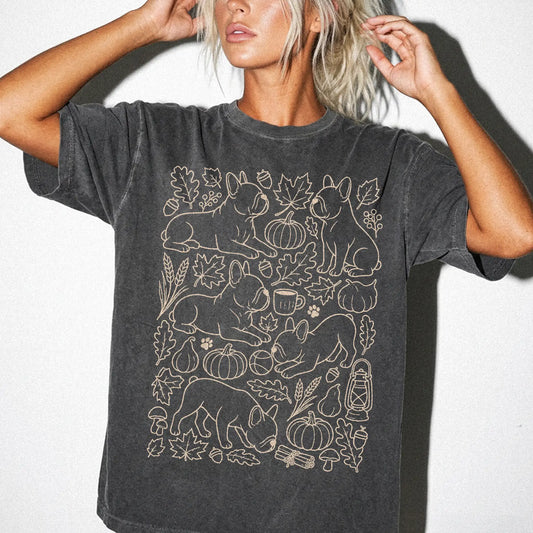 Model wearing a Pepper Comfort Colors® T-shirt with French Bulldog dogs with pumpkins, leaves, acorns, and woodland details
