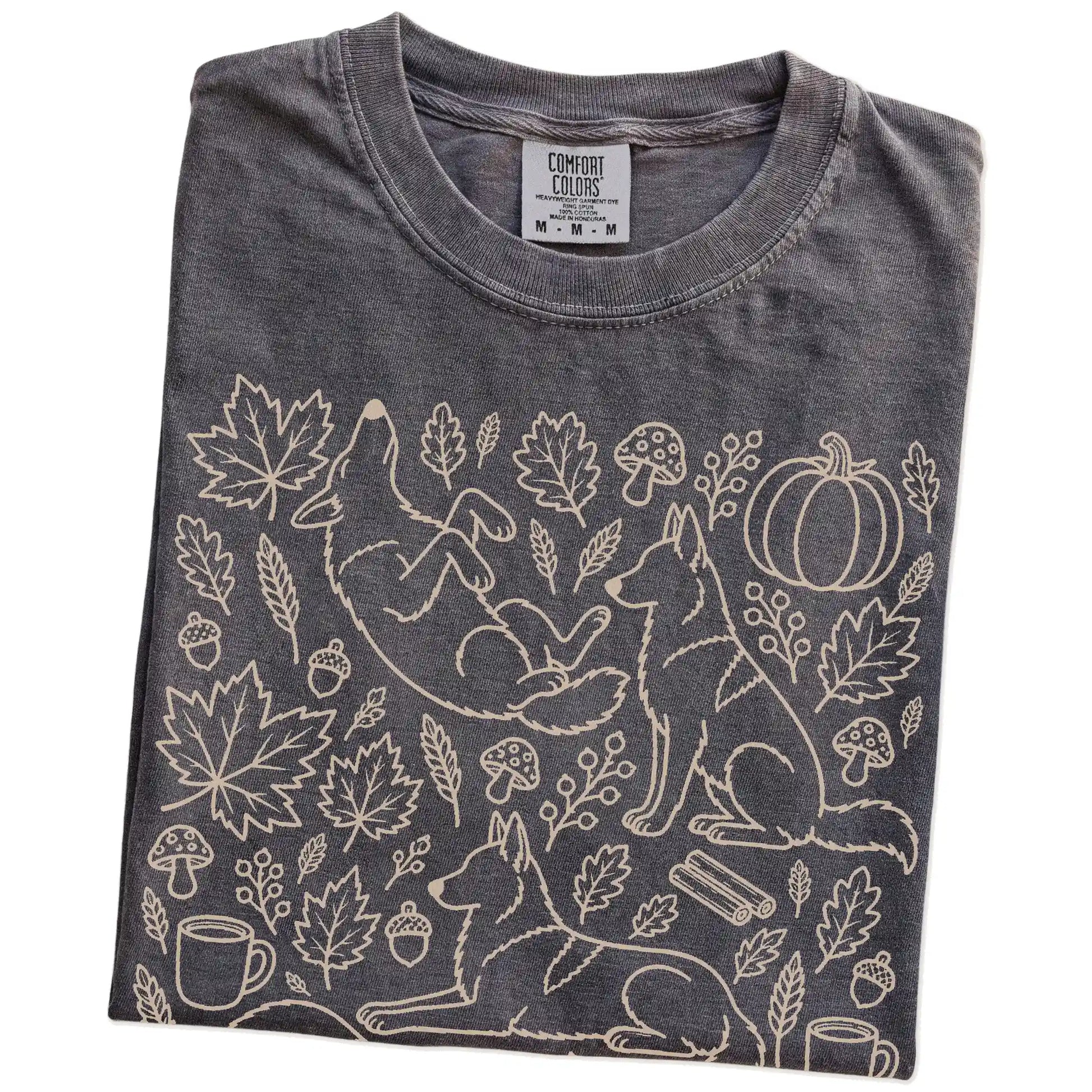 Folded Pepper Comfort Colors® T-shirt showing German Shepherd dogs with pumpkins, leaves, acorns, and woodland details