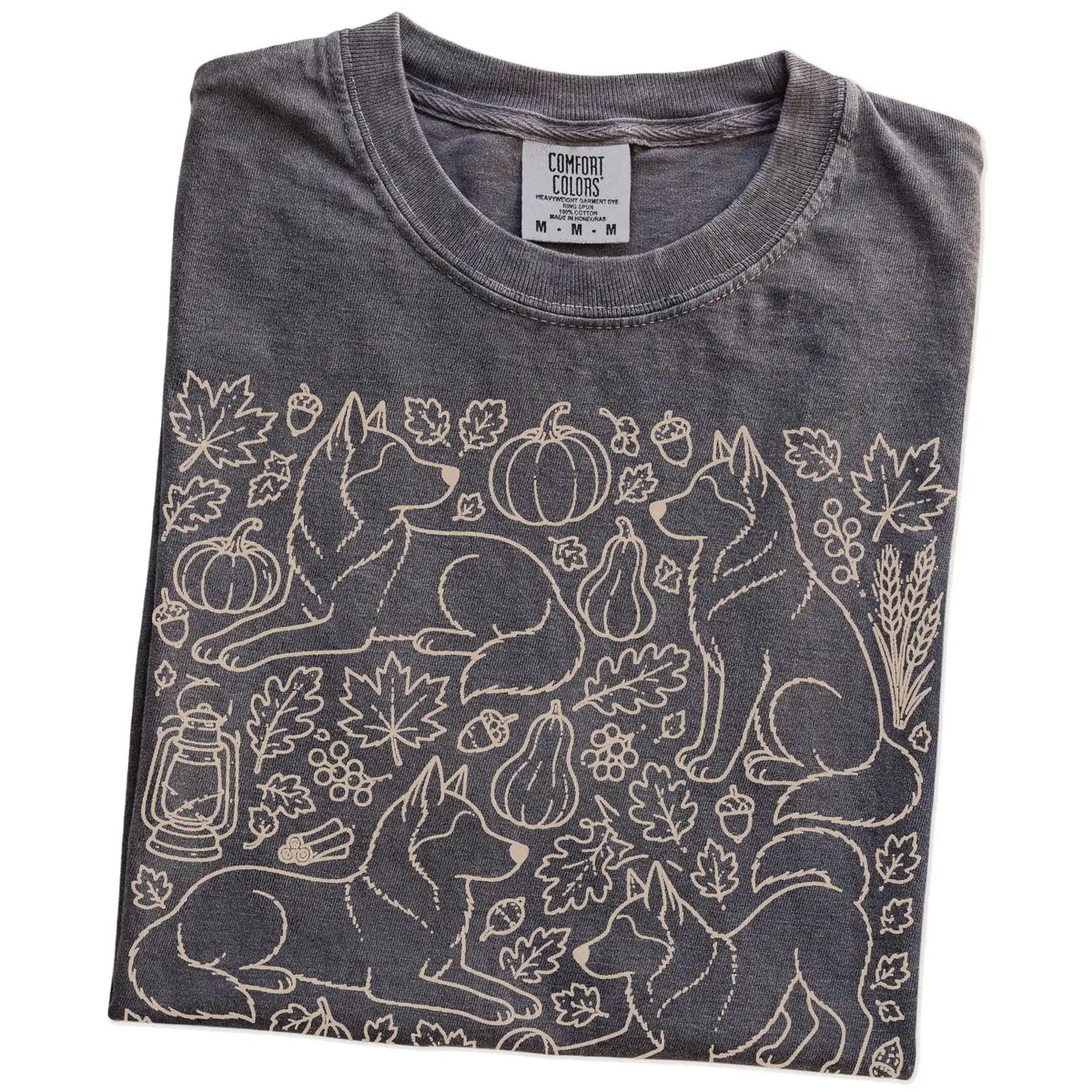 Folded Pepper Comfort Colors® T-shirt showing Husky dogs with pumpkins, leaves, acorns, and woodland details