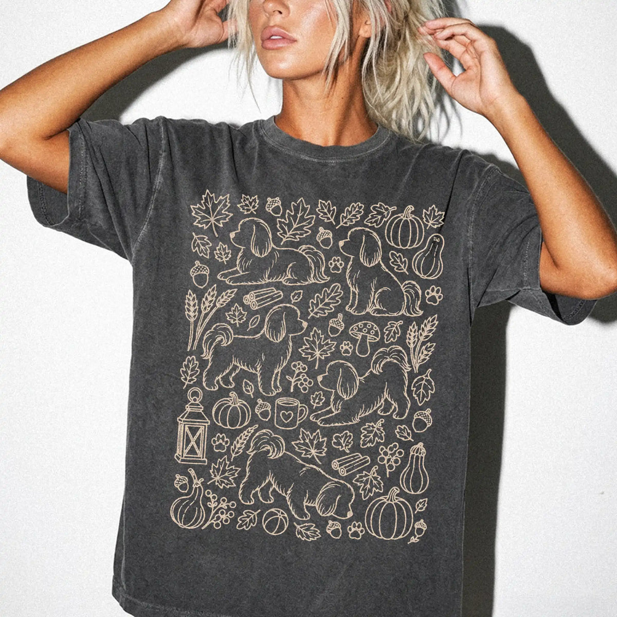 Model wearing a Pepper Comfort Colors® T-shirt with Maltese dogs with pumpkins, leaves, acorns, and woodland details