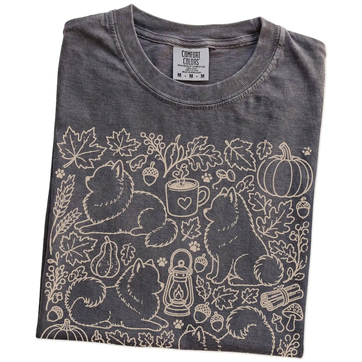 Folded Pepper Comfort Colors® T-shirt showing Pomeranian dogs with pumpkins, leaves, acorns, and woodland details