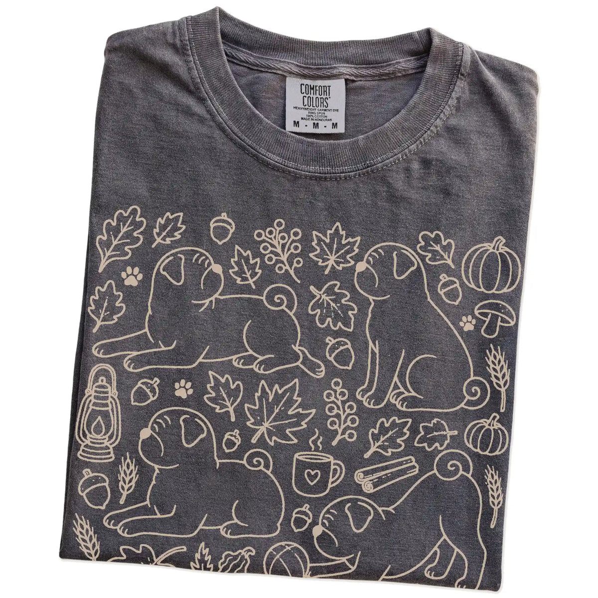 Folded Pepper Comfort Colors® T-shirt showing Pug dogs with pumpkins, leaves, acorns, and woodland details