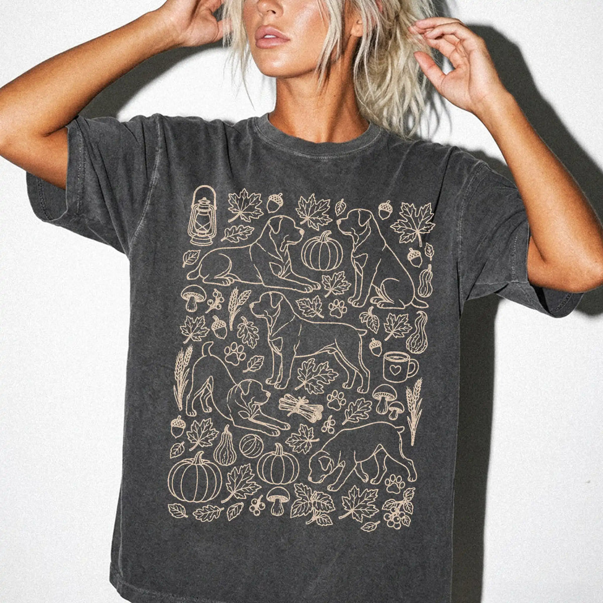 Model wearing a Pepper Comfort Colors® T-shirt with Rottweiler dogs with pumpkins, leaves, acorns, and woodland details