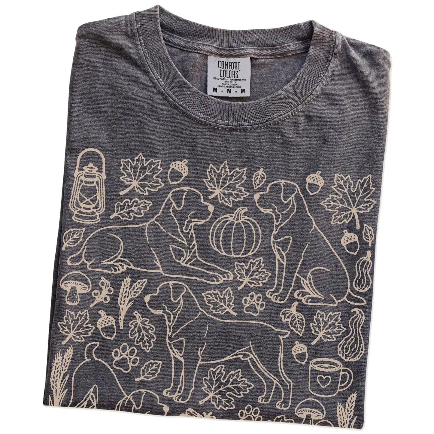 Folded Pepper Comfort Colors® T-shirt showing Rottweiler dogs with pumpkins, leaves, acorns, and woodland details