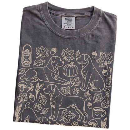 Folded Pepper Comfort Colors® T-shirt showing Rottweiler dogs with pumpkins, leaves, acorns, and woodland details