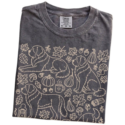 Folded Pepper Comfort Colors® T-shirt showing Saint Bernard dogs with pumpkins, leaves, acorns, and woodland details