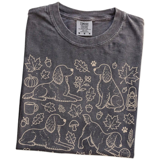 Folded Pepper Comfort Colors® T-shirt showing Springer Spaniel dogs with pumpkins, leaves, acorns, and woodland details