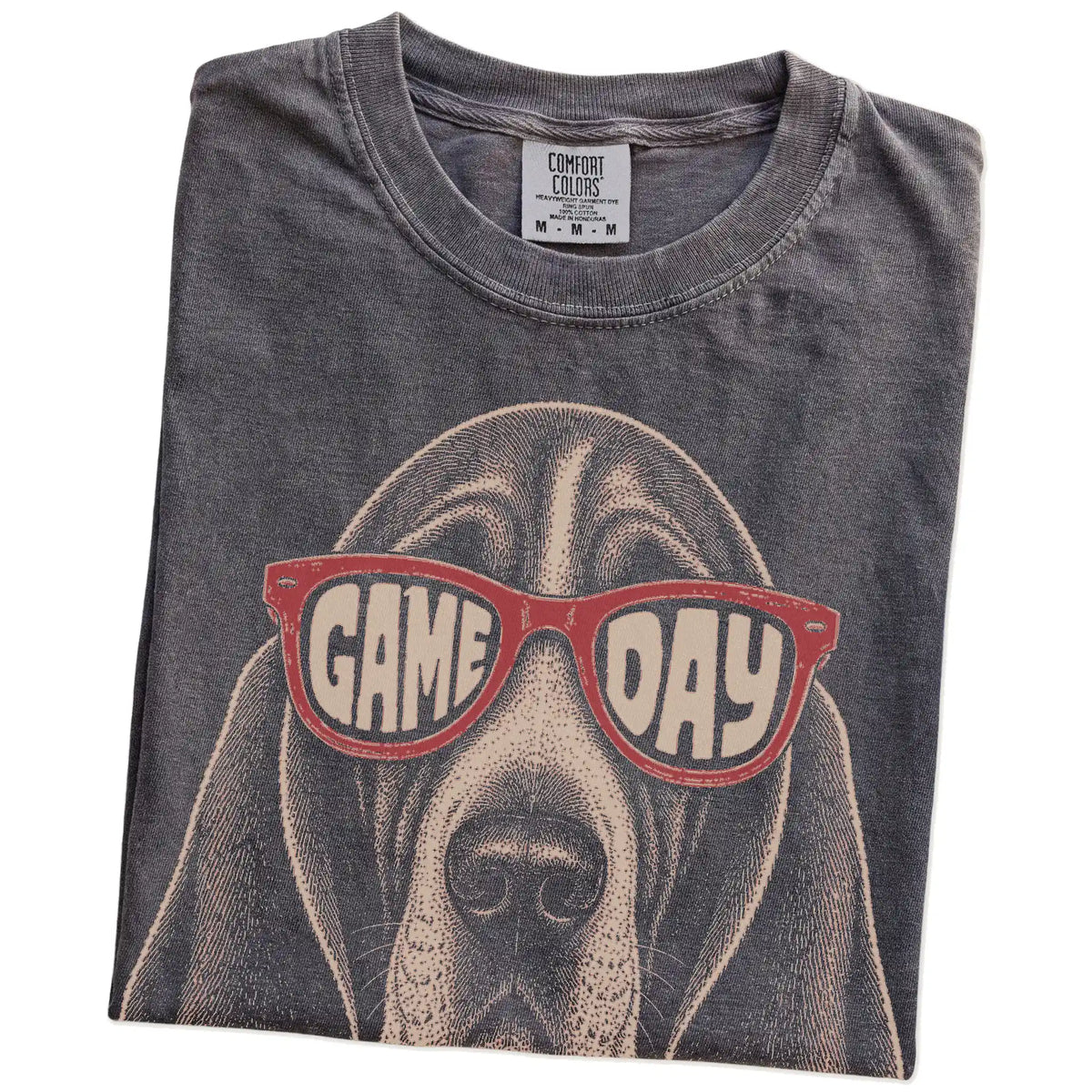 Folded Pepper Comfort Colors® T-shirt showing basset hound wearing red game day sunglasses