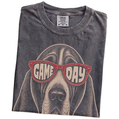 Folded Pepper Comfort Colors® T-shirt showing basset hound wearing red game day sunglasses