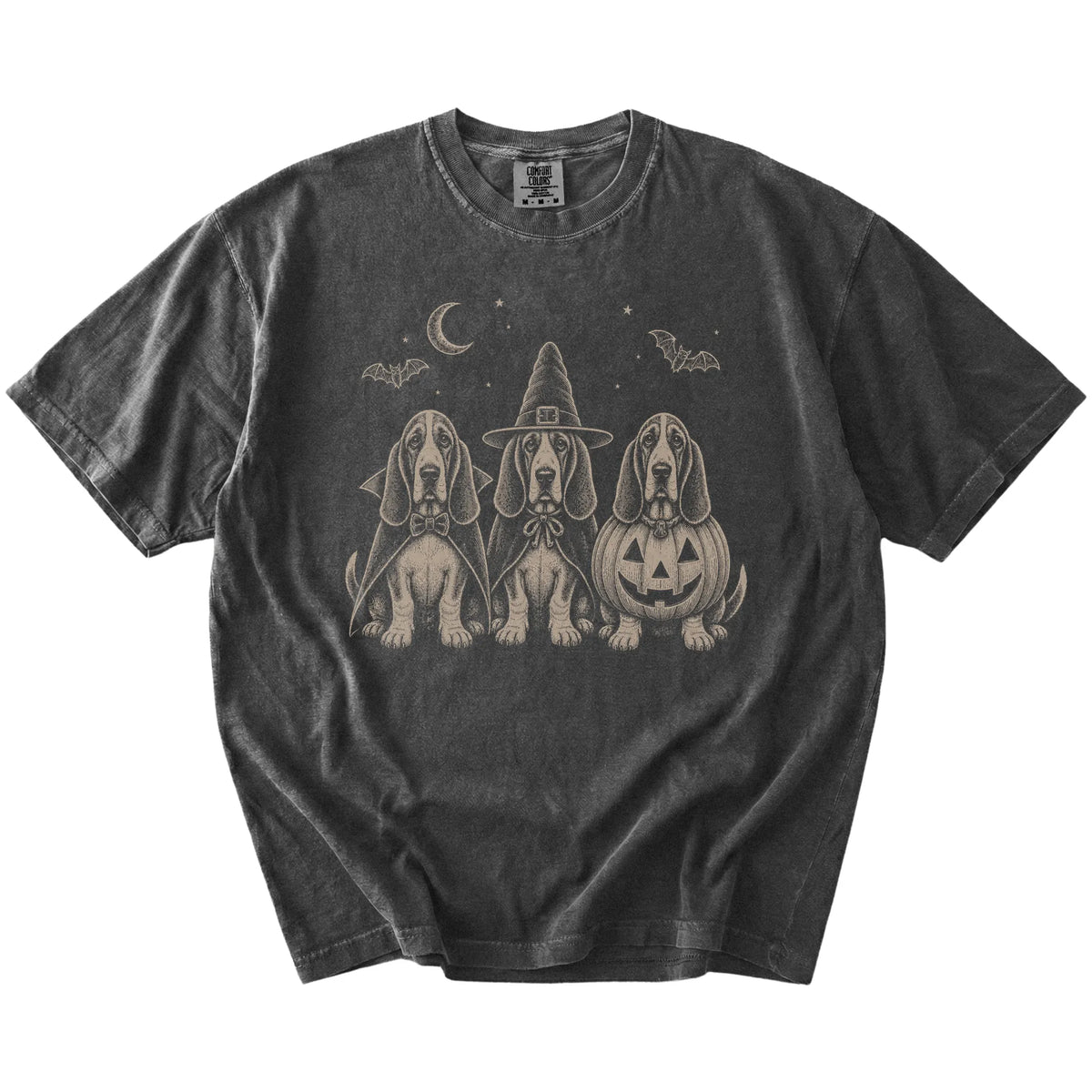 Three Basset Hound dogs dressed for Halloween beneath bats and a crescent moon on a Pepper Comfort Colors® T-shirt