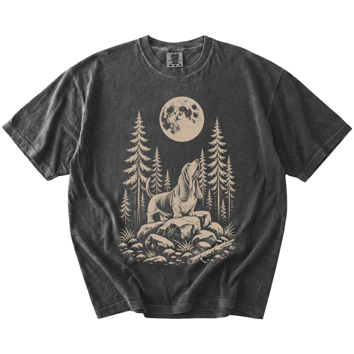 Basset Hound howling beneath the moon and pine trees on a Pepper Comfort Colors® T-shirt