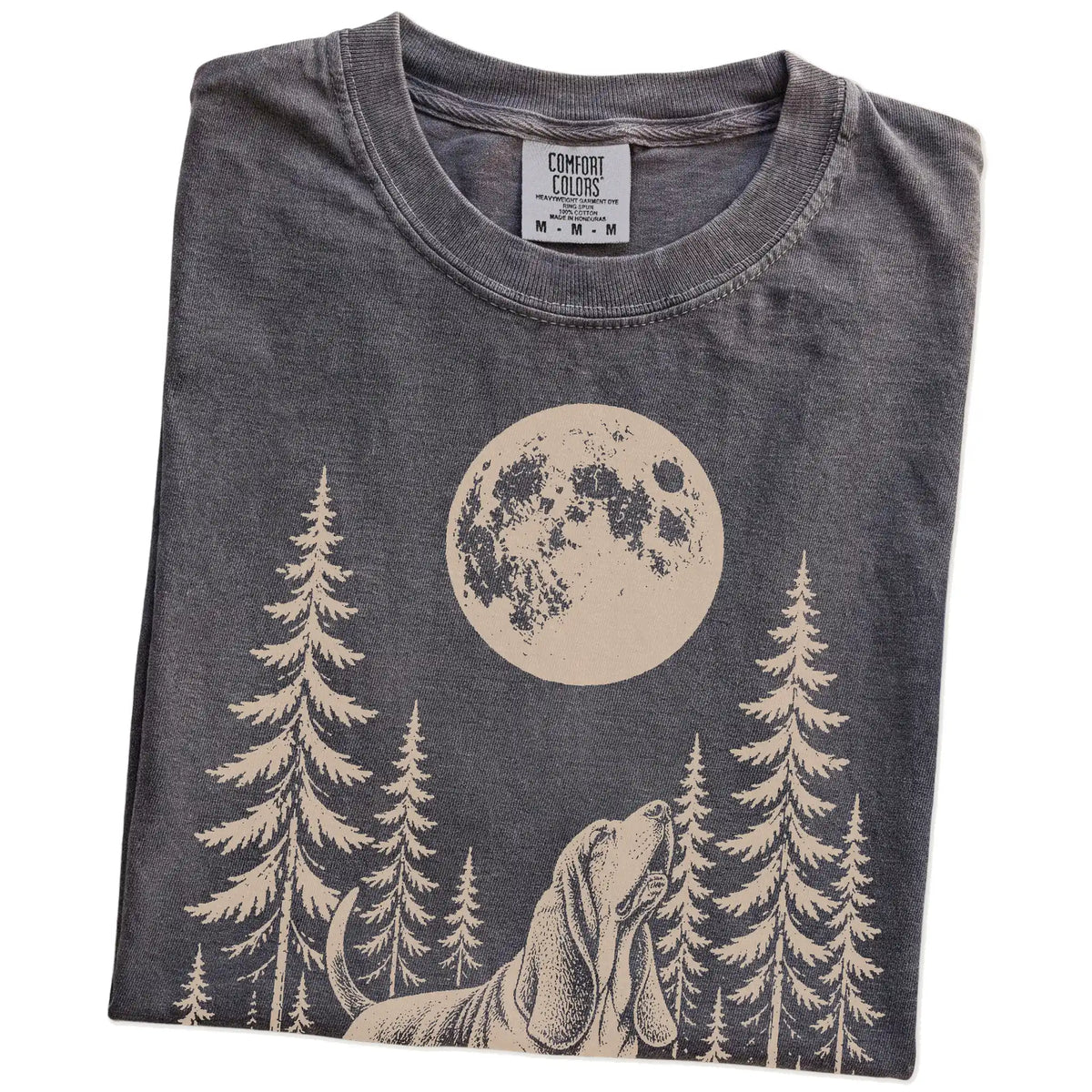 Folded Pepper Comfort Colors® T-shirt showing a Basset Hound howling beneath the moon and pine trees