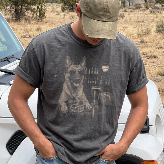 Model wearing a Pepper Comfort Colors® T-shirt featuring Belgian Malinois with beer and football graphics