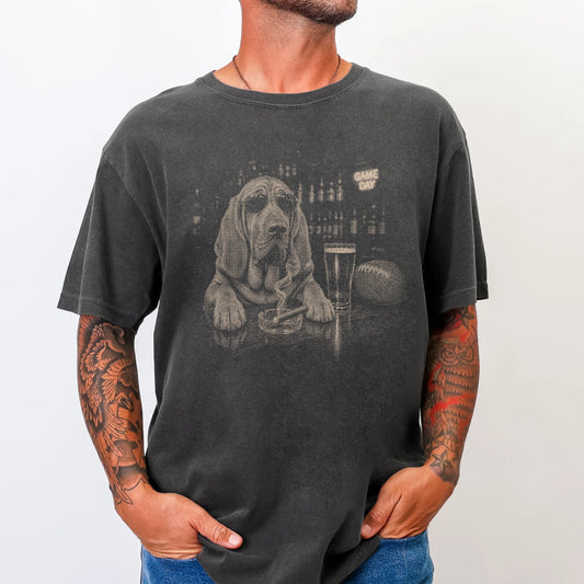 Model wearing a Pepper Comfort Colors® T-shirt featuring Bloodhound with beer and football graphics