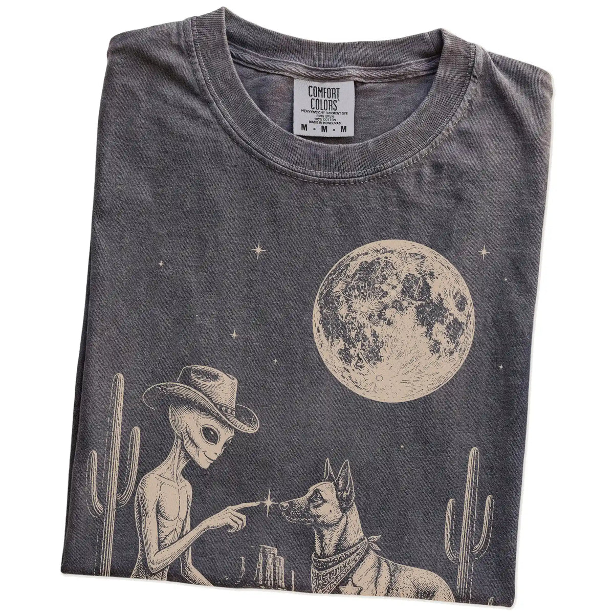 Folded Pepper Comfort Colors® T-shirt showing cowboy alien fist-bumping a belgian malinois beneath the moon