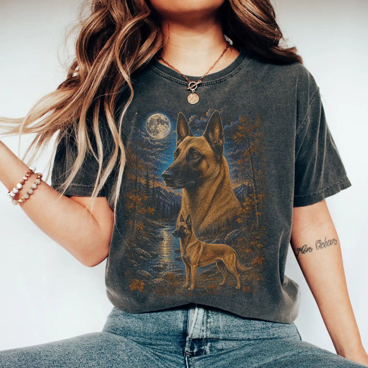 Model wearing a pepper T-shirt with Belgian Malinois Autumn Moon artwork.